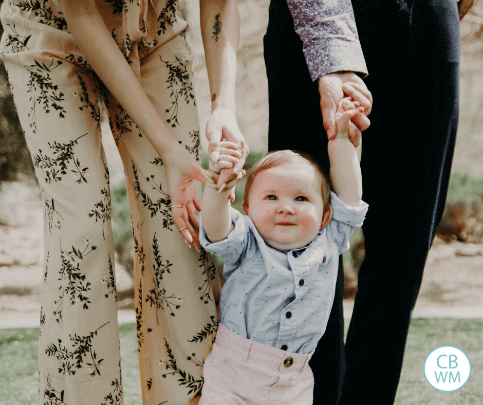 Baby walking with parents