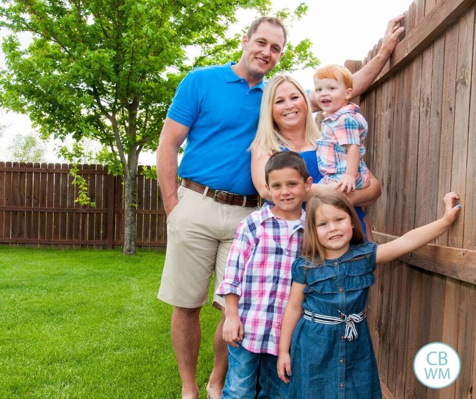 smiling family standing outside