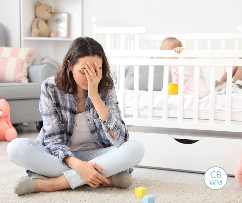 Stressed out mom with her baby in the crib