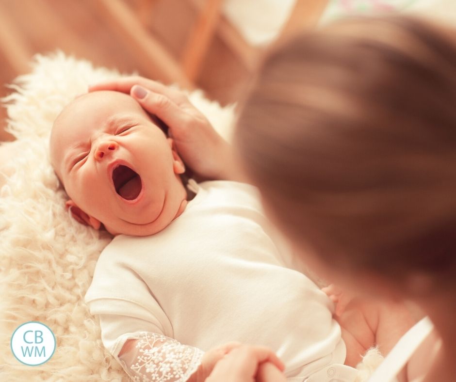 Mom waking a sleeping baby