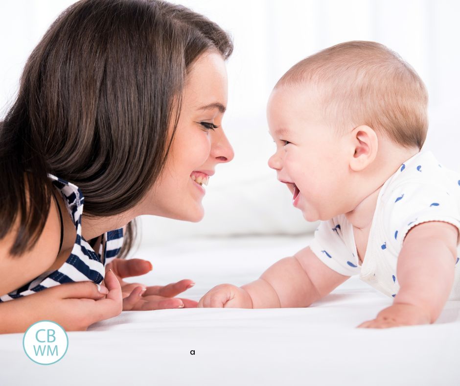 Mom and baby on tummies smiling at each other