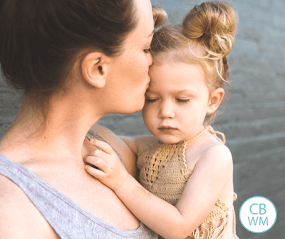 Mom kissing her toddler's forehead