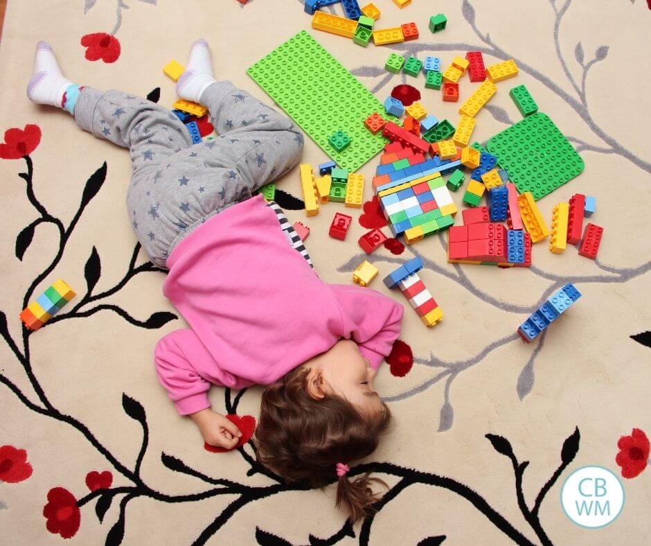 toddler sleeping on floor with LEGOs