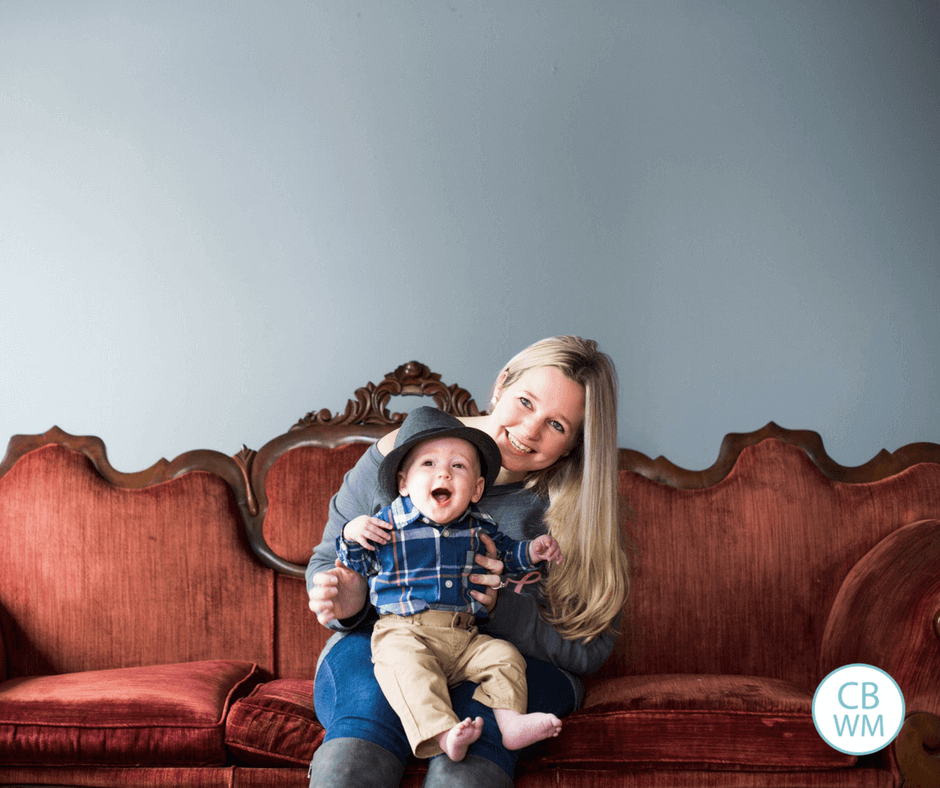 Mom holding her baby while sitting on a couch