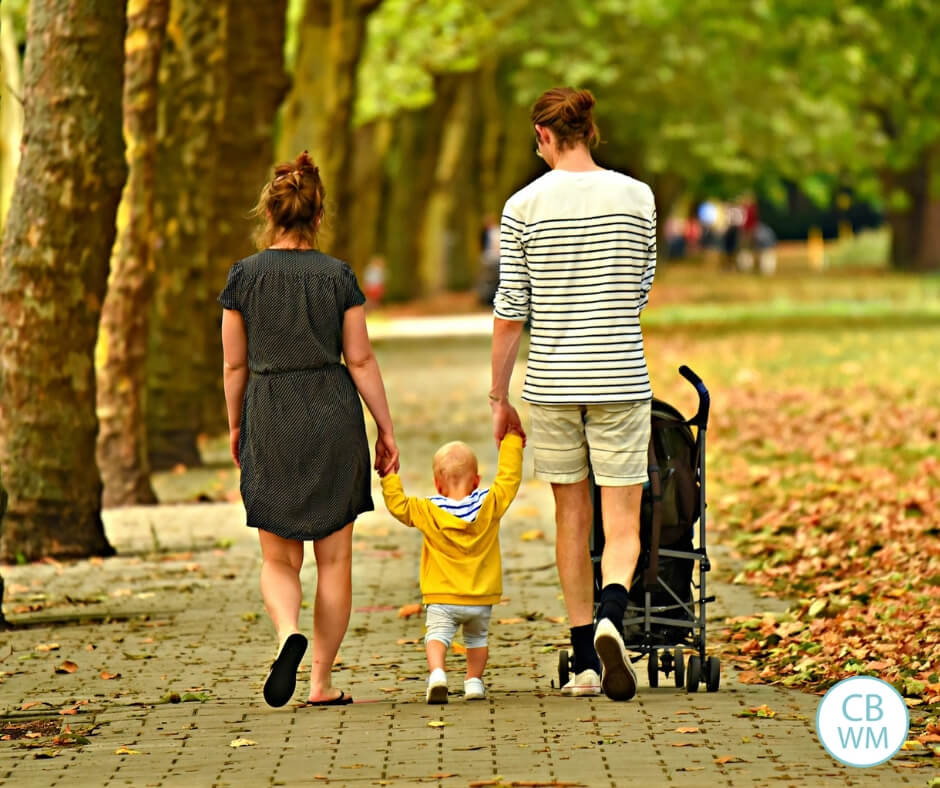 Parents walking with their first born child.