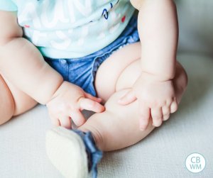 Baby sitting on couch. No face--just the body.