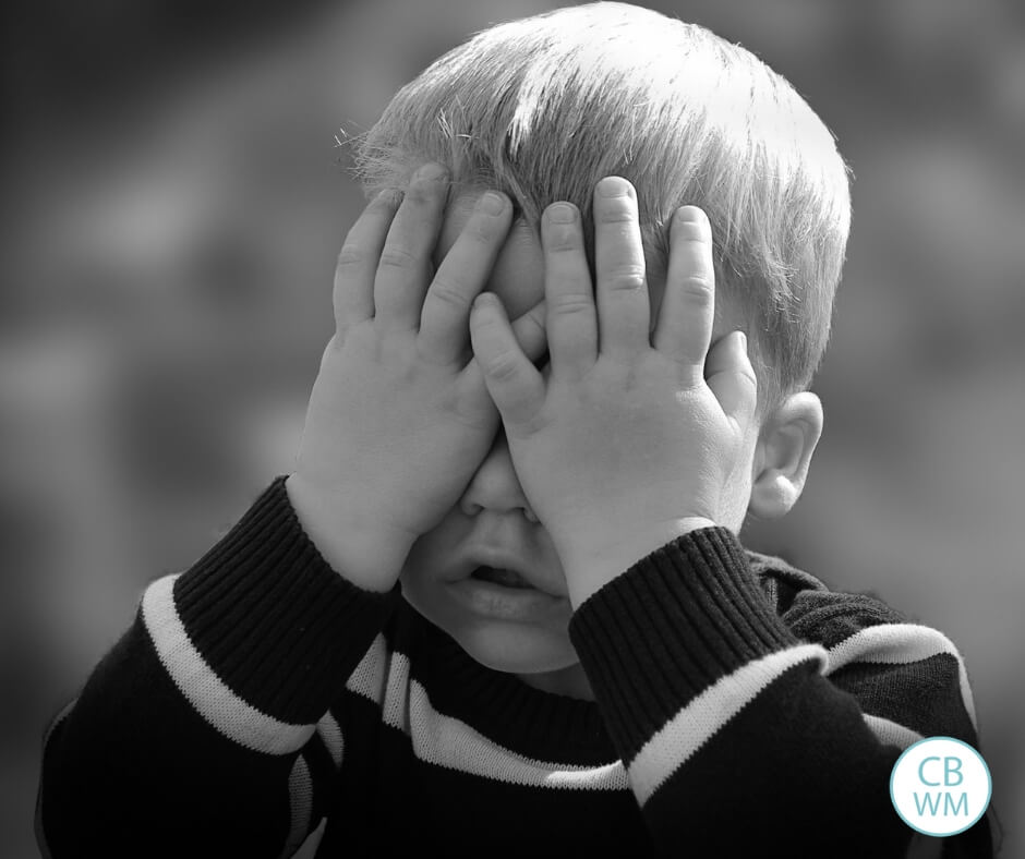 Toddler boy covering his eyes