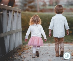 Boy and girl walking across a bridge together