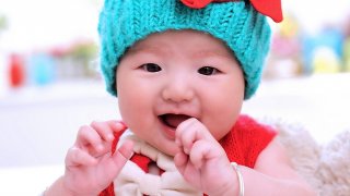 Baby girl with blue hat and a red shirt