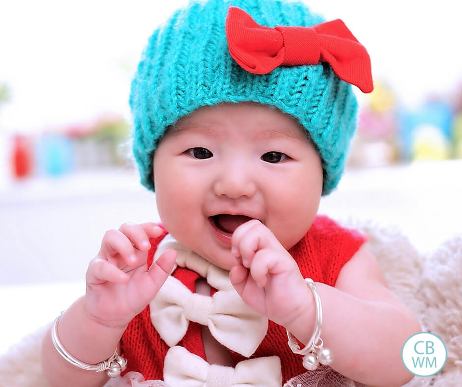 Baby girl with blue hat and a red shirt