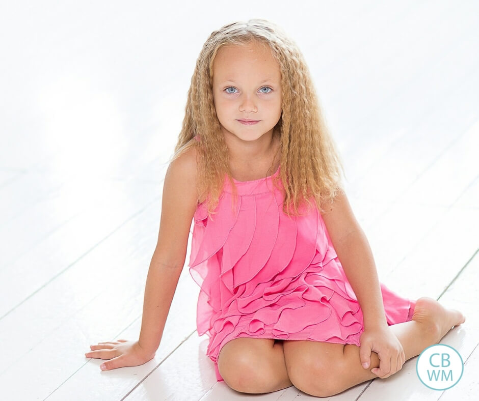 Girl in a pink dress sitting on the floor