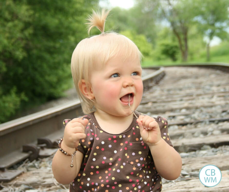 Toddler girl sitting on the train tracks