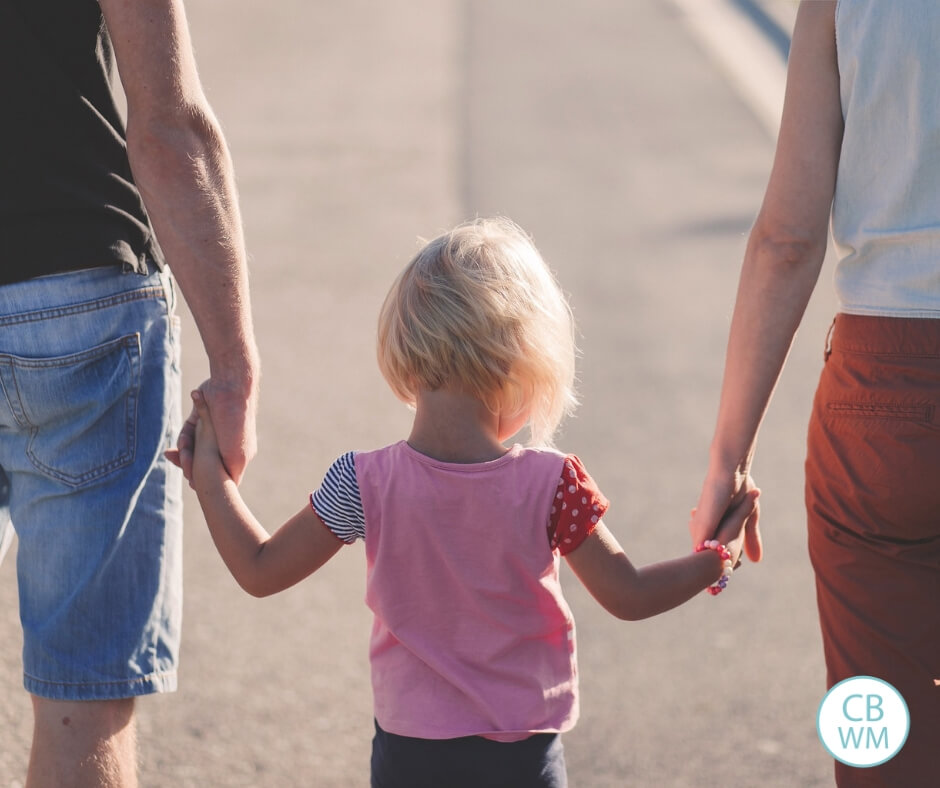 Parents holding the hands of a toddler