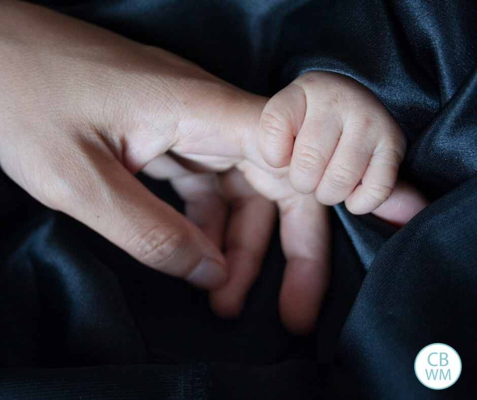 Baby holding mom's finger