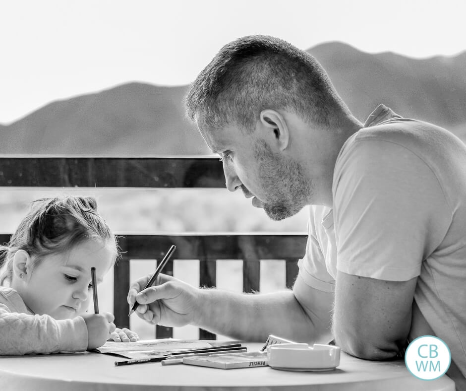 black and white photo of a dad and daughter writing together