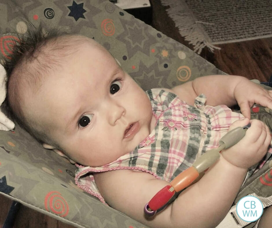 4 month old baby girl sitting in a bouncer