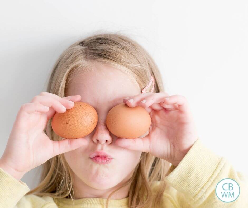 Girl holding eggs over her eyes