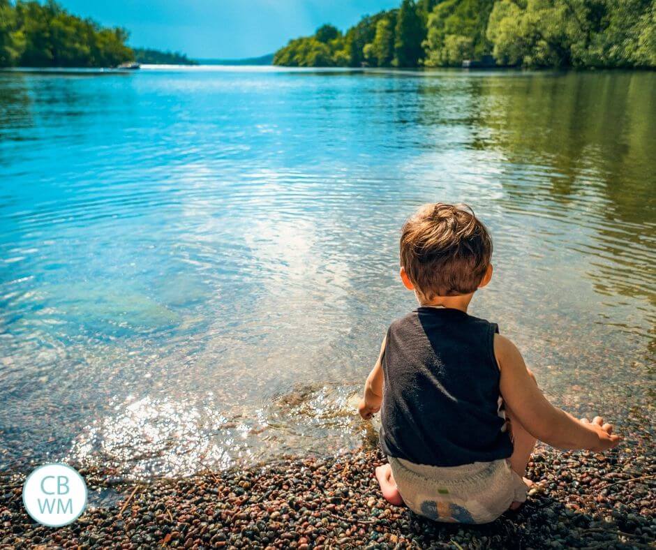 boy sitting on shore of the lake