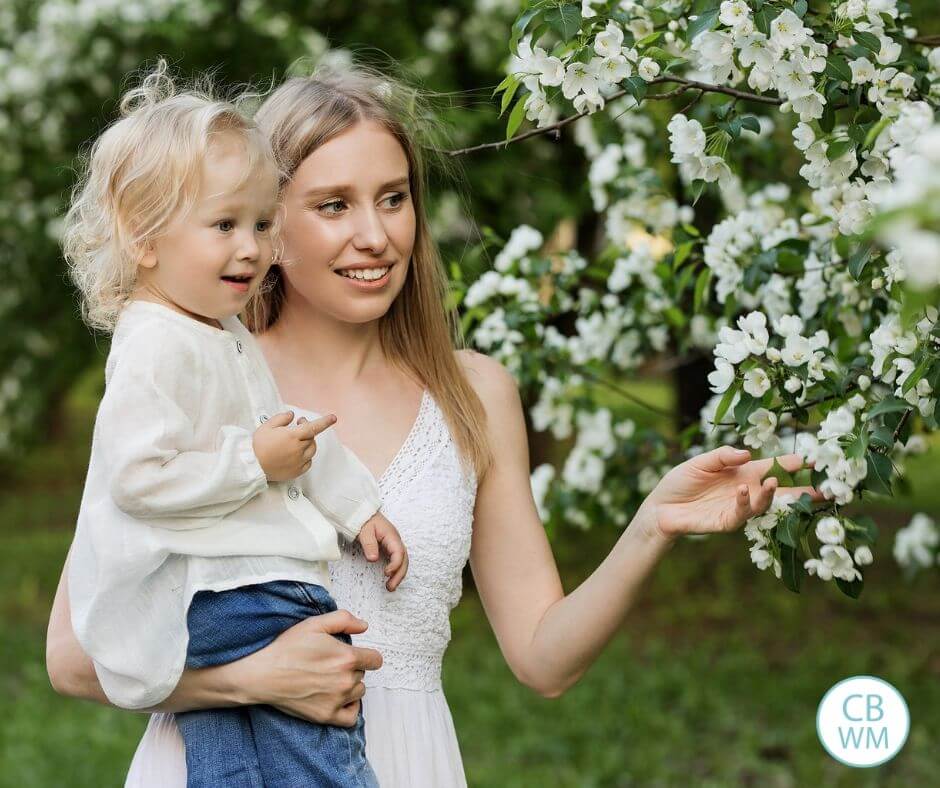 Picture of a mom and her daughter by flowering trees