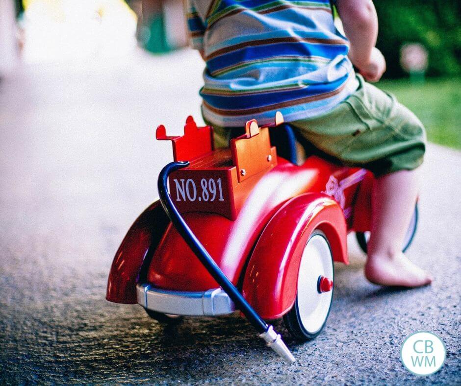 Toddler riding on a toy car