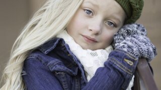 Blonde girl wearing a green beret looking at the camera