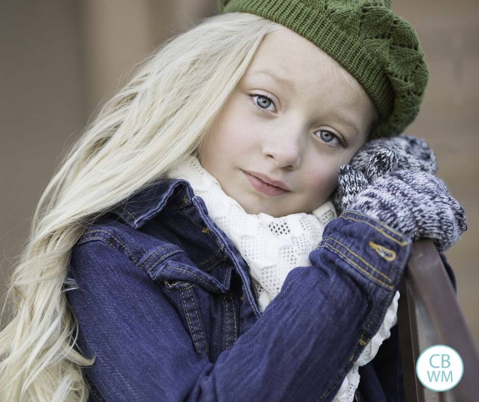 Blonde girl wearing a green beret looking at the camera