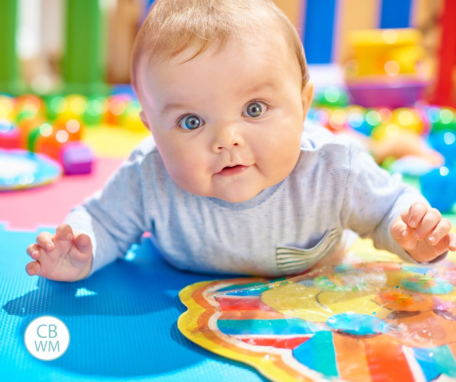 Baby on the tummy on a colorful fun mat