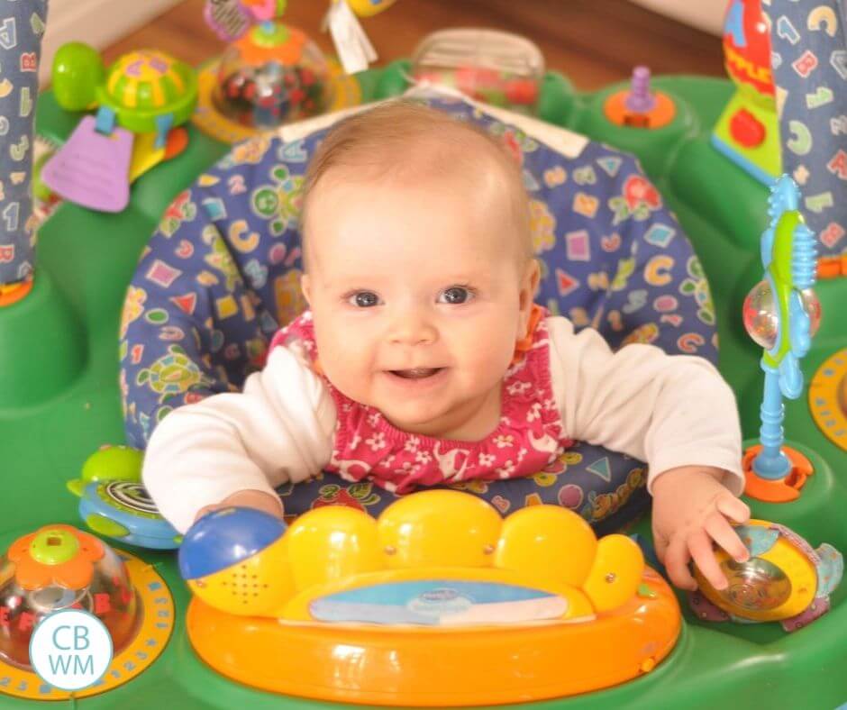 5 month old baby girl playing in an exersaucer