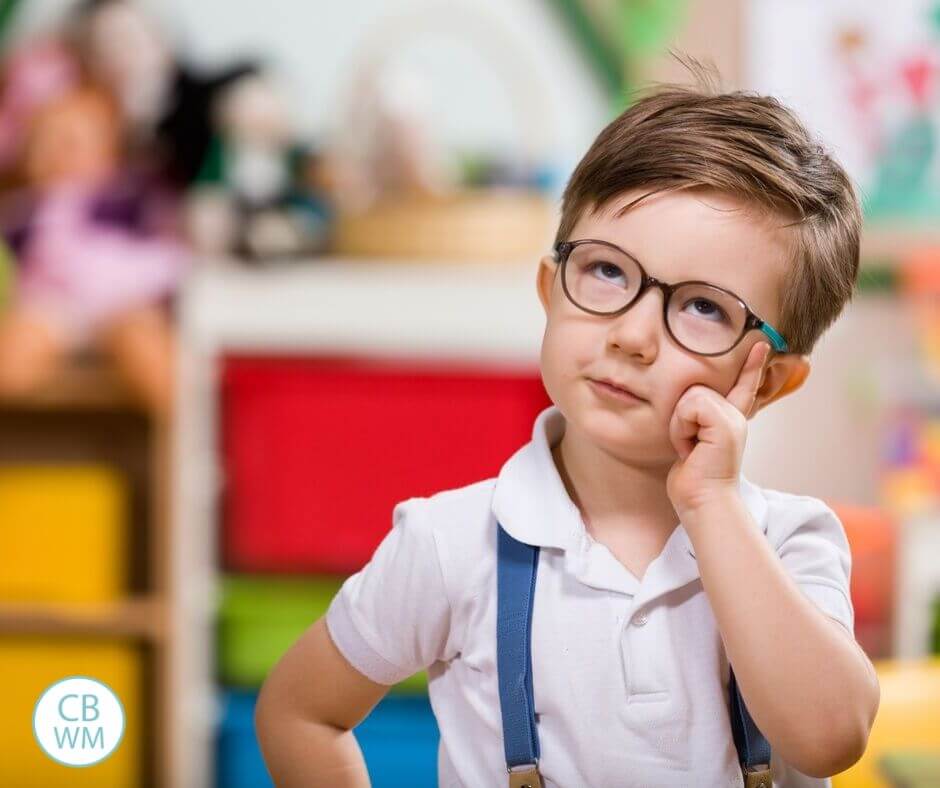 Preschooler wearing suspenders deep in thought