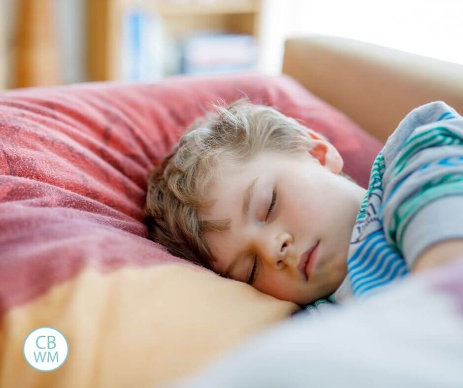 Presechooler sleeping on a red and gold pillow