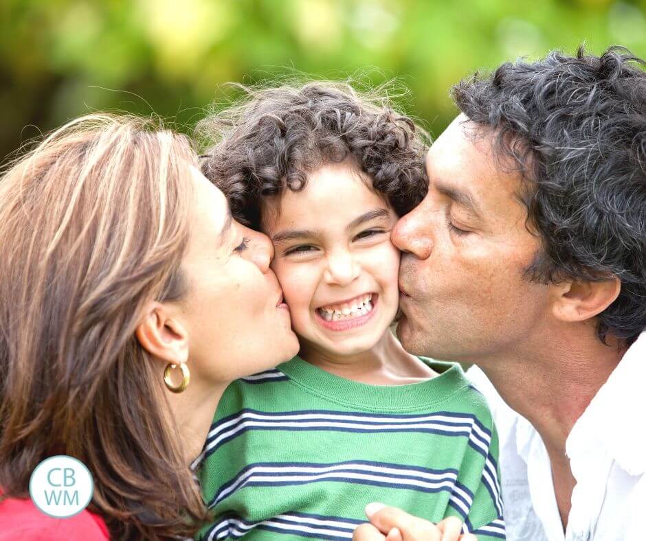 Parents kissing kid's cheek