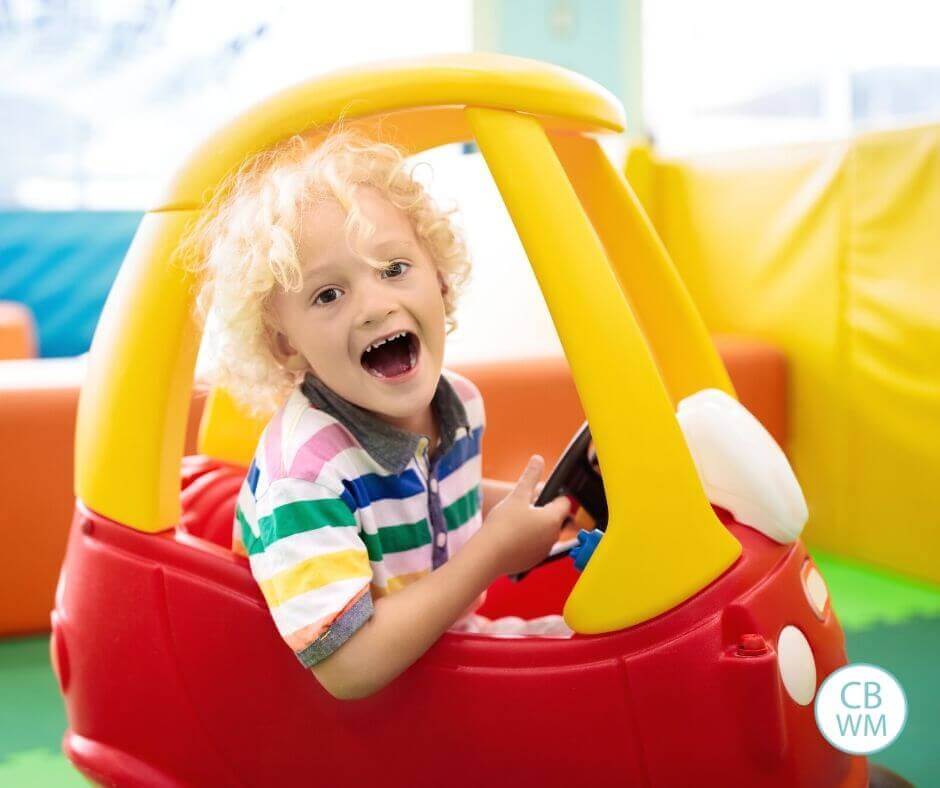 Boy playing in a Cozy Coupe