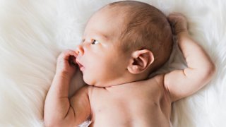 Newborn baby lying on a white blanket