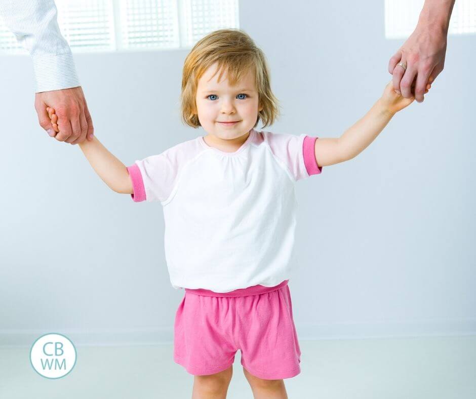 Pretoddler holding parents' hands