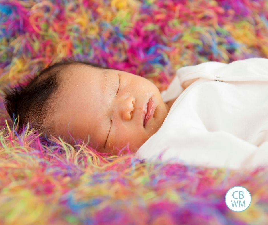 baby sleeping on colorful blanket