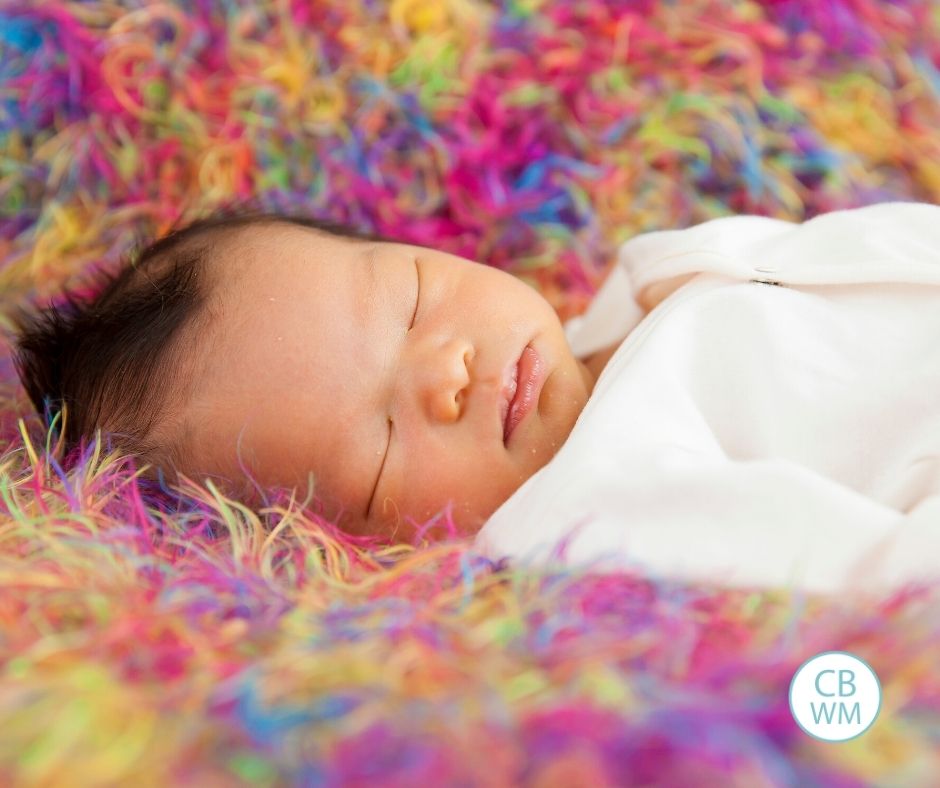 baby sleeping on colorful blanket