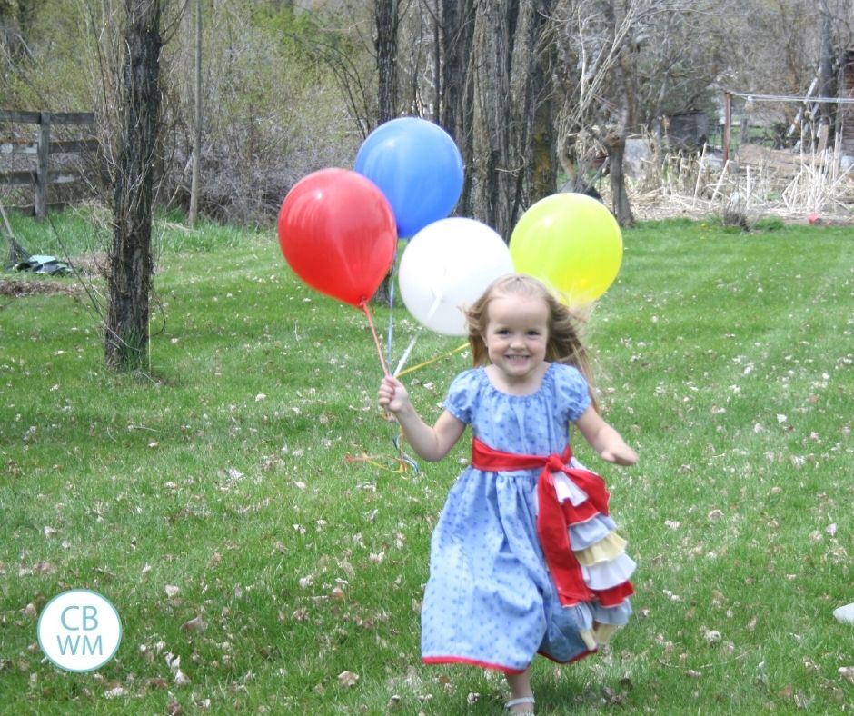 4 year old Kaitlyn running toward camera with balloons