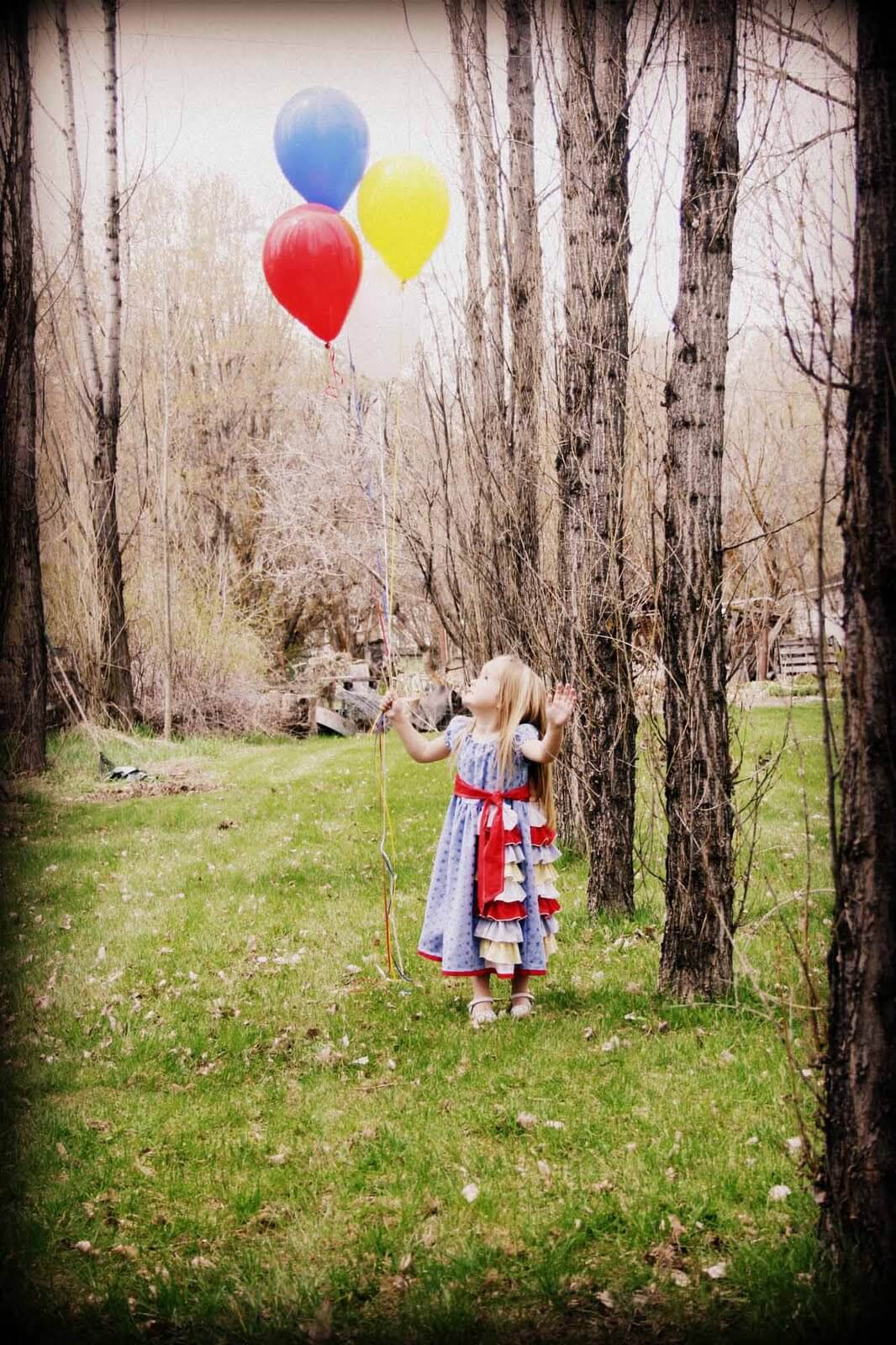 4 year old Kaitlyn holding 4 balloons