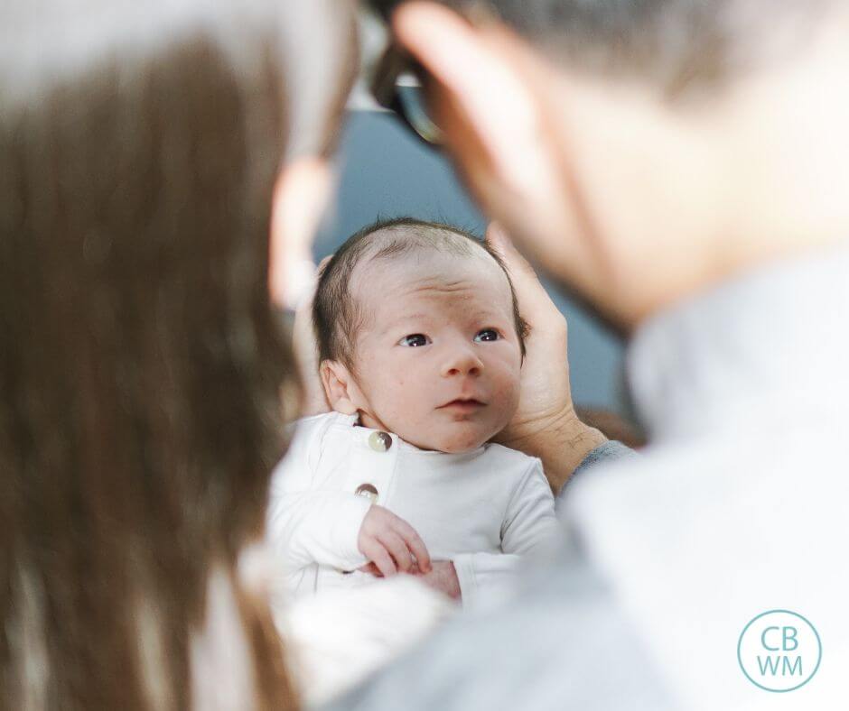 Young baby being held by both parents