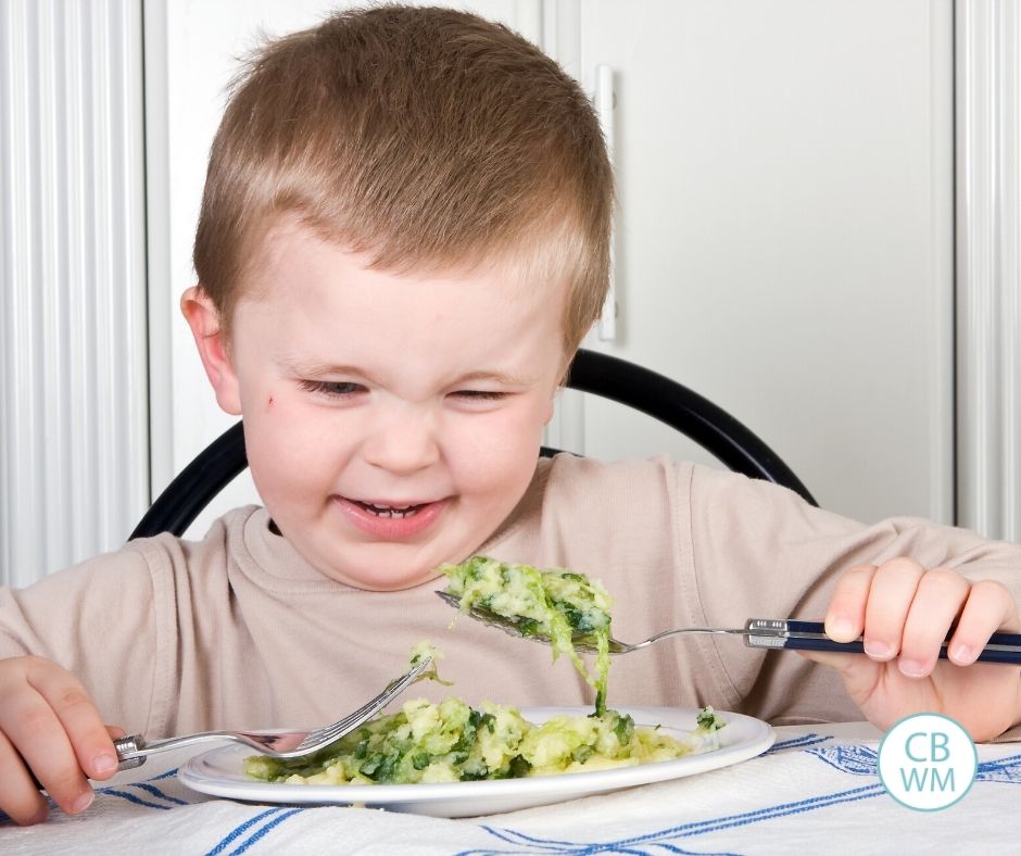 Child being picky about eating broccoli at the dinner table