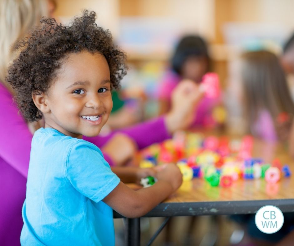 Child at table with other children in school