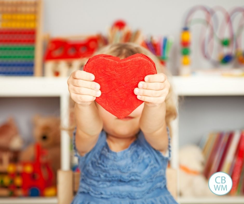 Child holding up a red heart