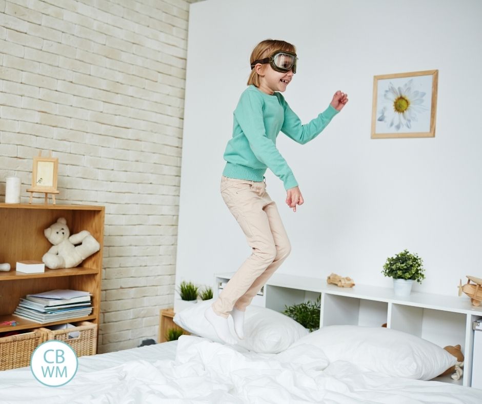 child jumping on bed