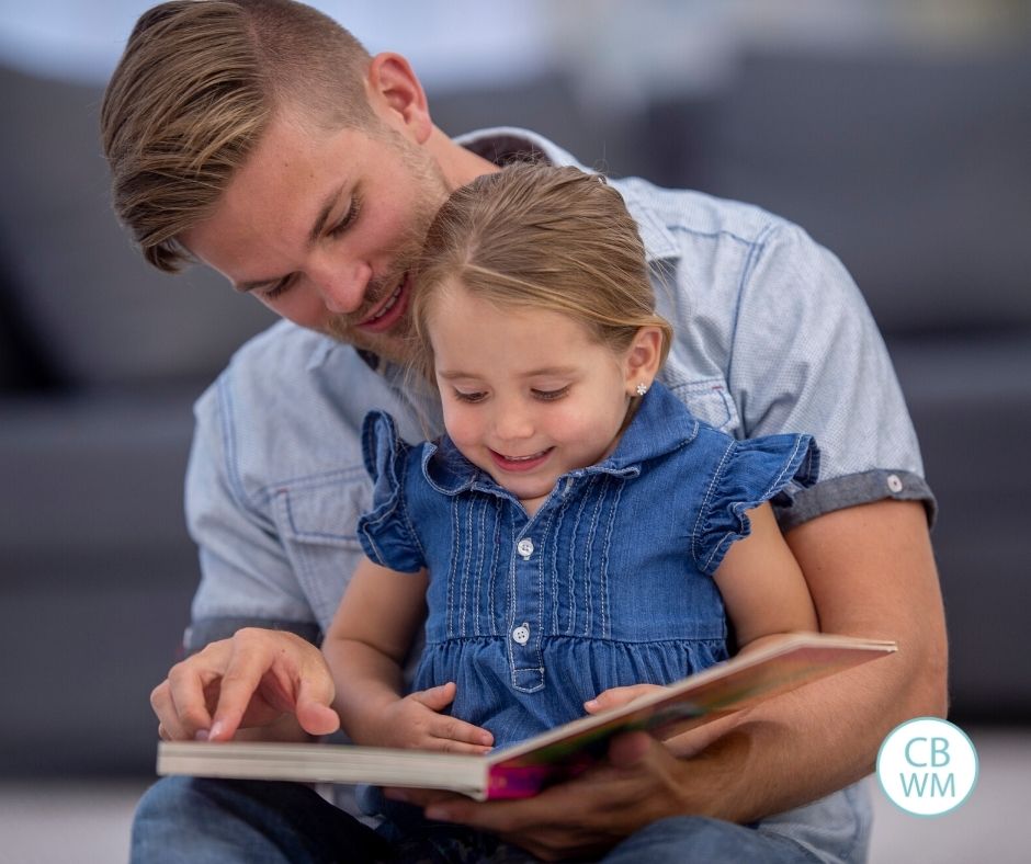 Father reading a book to his daughter