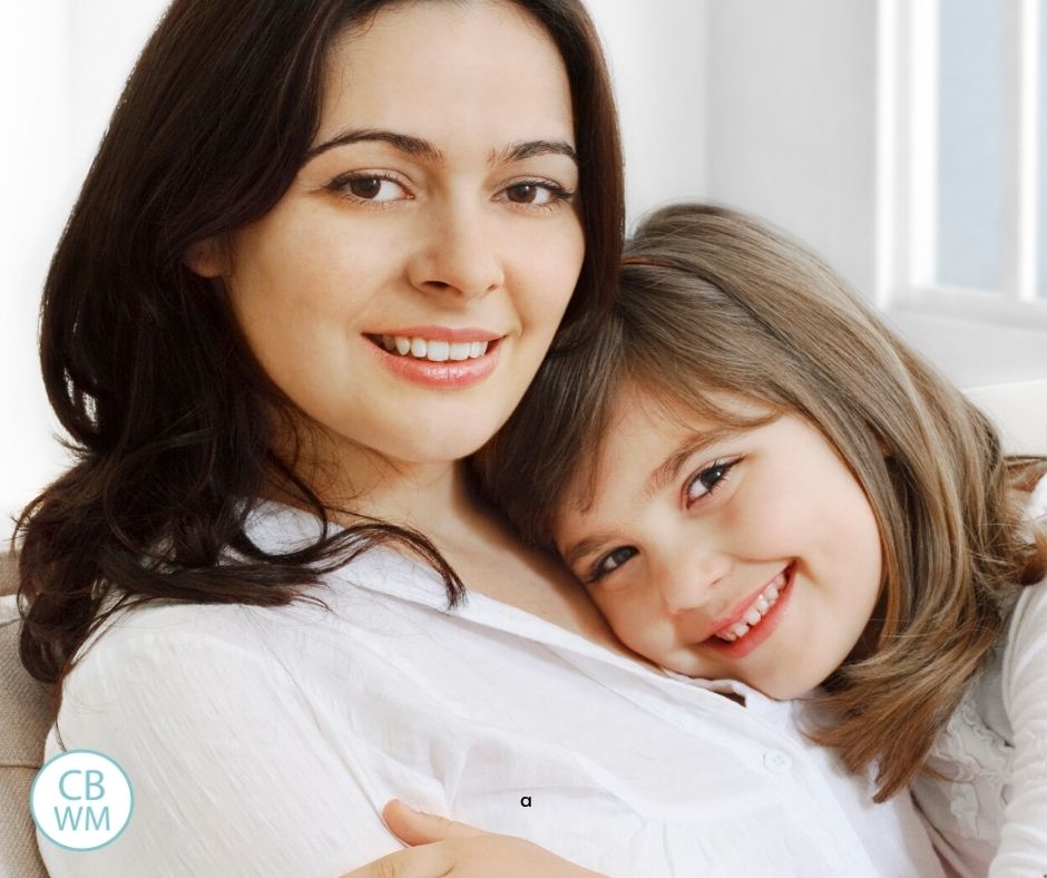 Mom and daughter cuddling on couch