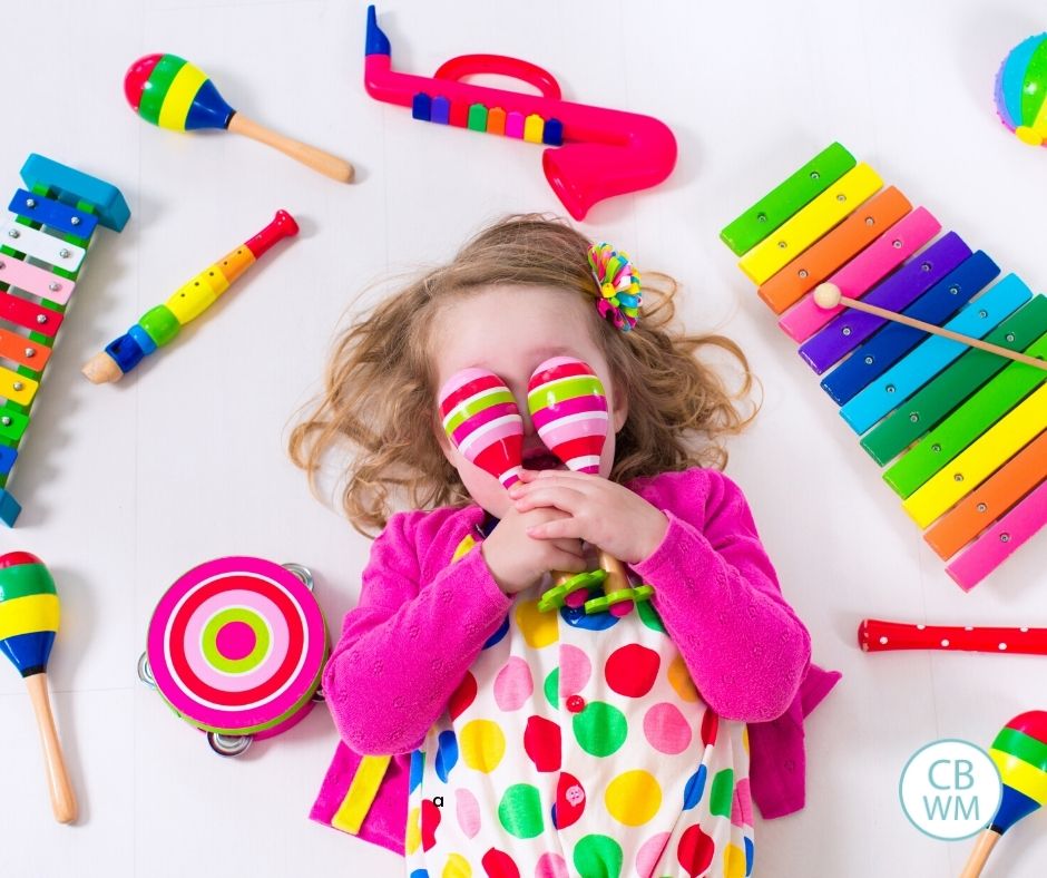 preschooler girl playing with musical instrument toys