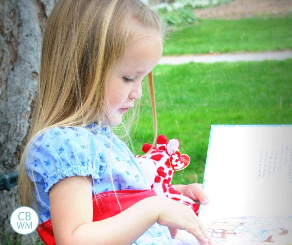 Four year old girl reading a book