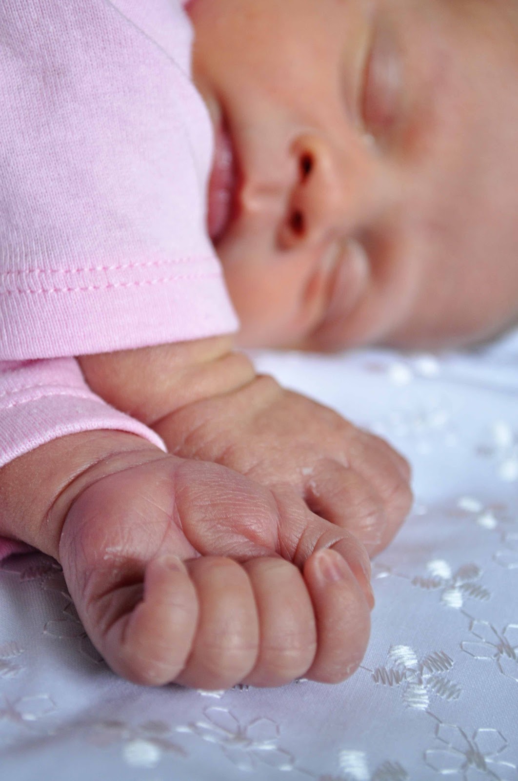 Newborn Brinley laying on a white blanket sleeping