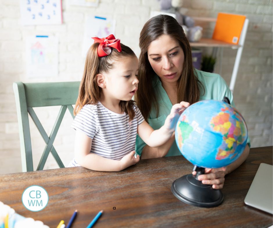 mother homeschooling her daughter and examining a globe together