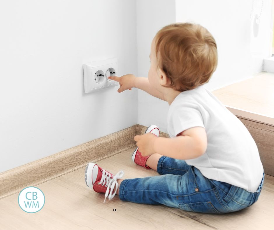 baby sitting at an electrical outlet
